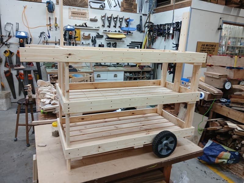 A timber wheeled stand on a workshop bench