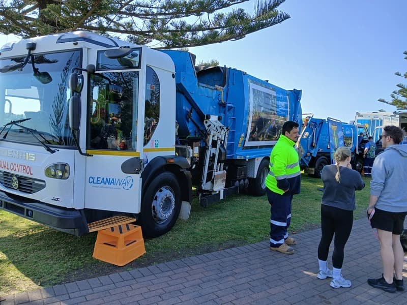 Garbage trucks on display at an outdoor festival
